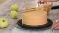 The process of decorating a cake with caramel cream cover.