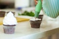 The process of decorating chocolate cupcakes with airy protein cream. Creation of cakes by professional pastry chefs