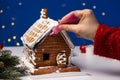 The process of decorating a ginger Christmas house with sugar icing