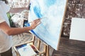 Process of drawing with oilpaints and paintbrush. Artist paints on canvas painting on easel in studio Royalty Free Stock Photo