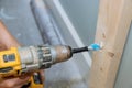 Process of drilling a hole in wall in order to allow cable to be laid along with renovation of house Royalty Free Stock Photo