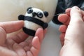 Process of felting a toy panda from a white and black wool