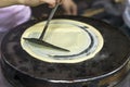 The process of frying pancakes, rolling out the dough on a hot pancake, forming a round pancake Royalty Free Stock Photo