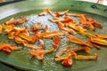 Process of frying roasting slices of red bell peppers capsicums in hot sizzling olive oil. Large flat paella or jambalaya pan