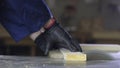 Close up of a young man in a furniture factory cutting the wooden pieces for the sofa