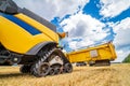 Process of gathering ripe crop from the fields. Side view on yellow combine. Harvest time. Royalty Free Stock Photo