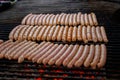 Process of grilling fresh meat sausages on big round grill