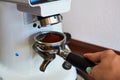 The process of grinding grain into holder for making espresso on coffee machine. Barista job at the coffee shop. Royalty Free Stock Photo