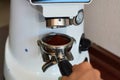 The process of grinding grain into holder for making espresso on coffee machine. Barista job at the coffee shop. Royalty Free Stock Photo