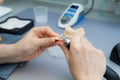 Process of grinding the jaw during production. The dental technician processes artificial teeth with a micromotor.