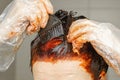 Process of hair dyeing in red colour using a brush. Young woman apply a red colour to her hair