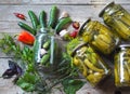 The process of home canning cucumbers in glass jars under lids for storage for the winter.Jars of cucumbers on a wooden background