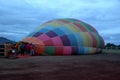 Process of inflation and preparation of hot air balloon at sunrise for flight in cloudy sky Royalty Free Stock Photo