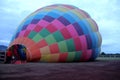 Process of inflation and preparation of hot air balloon at sunrise for flight in cloudy sky Royalty Free Stock Photo