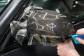 The process of installing PPF on the side mirror. Car wrapping close-up. Car wrapping. Royalty Free Stock Photo