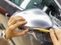 The process of installing PPF on the side mirror. Car wrapping. Royalty Free Stock Photo