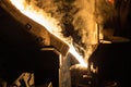 A process of ladle filling with molten hot steel from furnace with smoke - close-up with selective focus Royalty Free Stock Photo