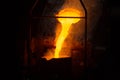 a process of ladle filling with molten hot steel from furnace with smoke - close-up with selective focus Royalty Free Stock Photo