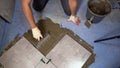 Renovation - Man construction worker laying floor tile. Process of laying floor ceramic tiles, application of the Royalty Free Stock Photo