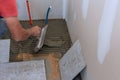 Process laying floor ceramic tiles, application of the adhesive base