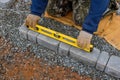 In the process of laying the paving stones in pavers stone pathway paving, a professional paver worker is performing the Royalty Free Stock Photo