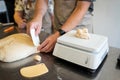 The process of making bread. Dividing the wheat dough into pieces for buns.
