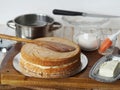 The process of making a cake Enchantress. Freshly baked cakes are joined with cream. White wooden table background with kitchen