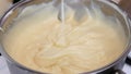 Process of making creamy custard by whisking the yolks, flour, sugar and hot milk in a large bowl. Dessert cream or sauce