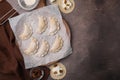 Process of making dumplings (varenyky) with cottage cheese. Raw dough and ingredients on brown table, flat lay. Royalty Free Stock Photo