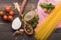 The process of making Food background for tasty Italian dishes with tomato. Various cooking ingredients with spaghetti and spoon.