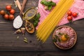 The process of making Food background for tasty Italian dishes with tomato. Various cooking ingredients with spaghetti and spoon.