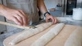 The process of making French traditional bread. Baguettes, notching the dough. Royalty Free Stock Photo