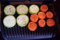 The process of making fresh zucchini and carrots on an electric grill. Vegetarian food. Fresh vegetables. Healthly food concept