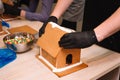 making a gingerbread house gluing the ginger roof with icing