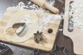 Wooden board with flour, dough and the cookie cutters in the shape of heart and star lie o Royalty Free Stock Photo