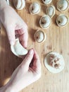 The process of making homemade dumplings. Raw homemade dumplings with meat on a wooden board with women hands Royalty Free Stock Photo