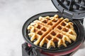 The process of making homemade waffles. Freshly baked waffles in a waffle iron. Royalty Free Stock Photo