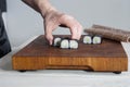 Process of making maki sushi. Cook chef hands preparing rolls with cheese, avocado and sesame seeds on wooden board Royalty Free Stock Photo