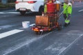 Process of making new road surface markings with a line striping machine, workers improve city infrastructure, demarcation marking Royalty Free Stock Photo