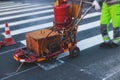 Process of making new road surface markings with a line striping machine, workers improve city infrastructure, demarcation marking Royalty Free Stock Photo