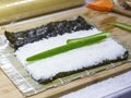 The process of making sushi and rolls with cucumber. Rice on nori sheet