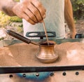 The process of making Turkish coffee on hot sand in a Turk. With male hands, barista Royalty Free Stock Photo