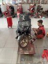 The process of a motorbike mechanic repairing a motorbike at a dealer.