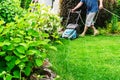 The process of mowing a lawn with an electric lawn mower. Foreground. Blurred Royalty Free Stock Photo