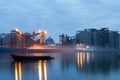 The process ofLoading cargo barges at the river port at night on a long shutter speed. The illuminated urban landscape