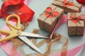 Process of packaging gift boxes. Thanks gifts. Wedding presents. Pink ribbon and yellow scissors. Red carton hearts. Royalty Free Stock Photo