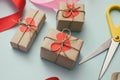 Process of packaging gift boxes. Thanks gifts. Wedding presents. Pink ribbon and yellow scissors. Red carton hearts. Royalty Free Stock Photo