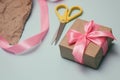 Process of packaging gift boxes. Thanks gifts. Wedding presents. Pink ribbon and yellow scissors. Royalty Free Stock Photo