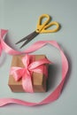 Process of packaging gift boxes. Thanks gifts. Wedding presents. Pink ribbon and yellow scissors. Royalty Free Stock Photo