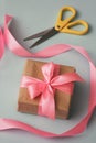 Process of packaging gift boxes. Thanks gifts. Wedding presents. Pink ribbon and yellow scissors. Royalty Free Stock Photo